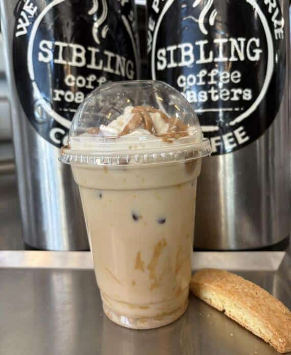 Iced coffee drink and biscotti at Bagel Chicks, showing what to order for the perfect spring picnic before heading to a nearby spot.
