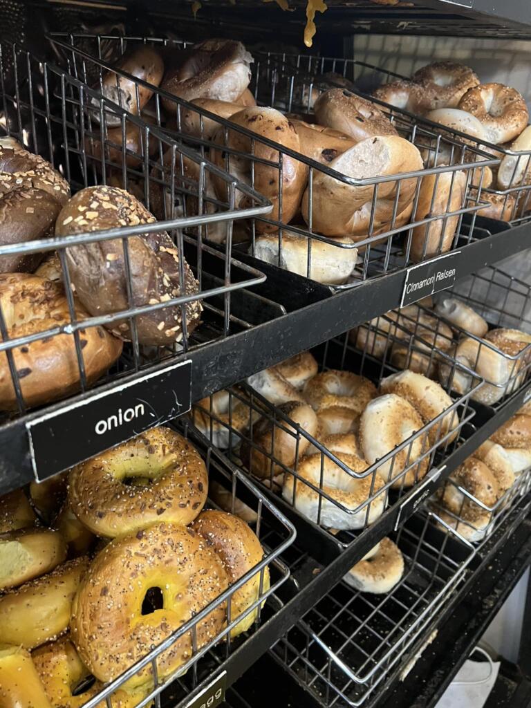 Assorted onion, cinnamon raisin, and seeded bagels in bakery baskets representing bagels taking over breakfast culture in the Mid-Atlantic.